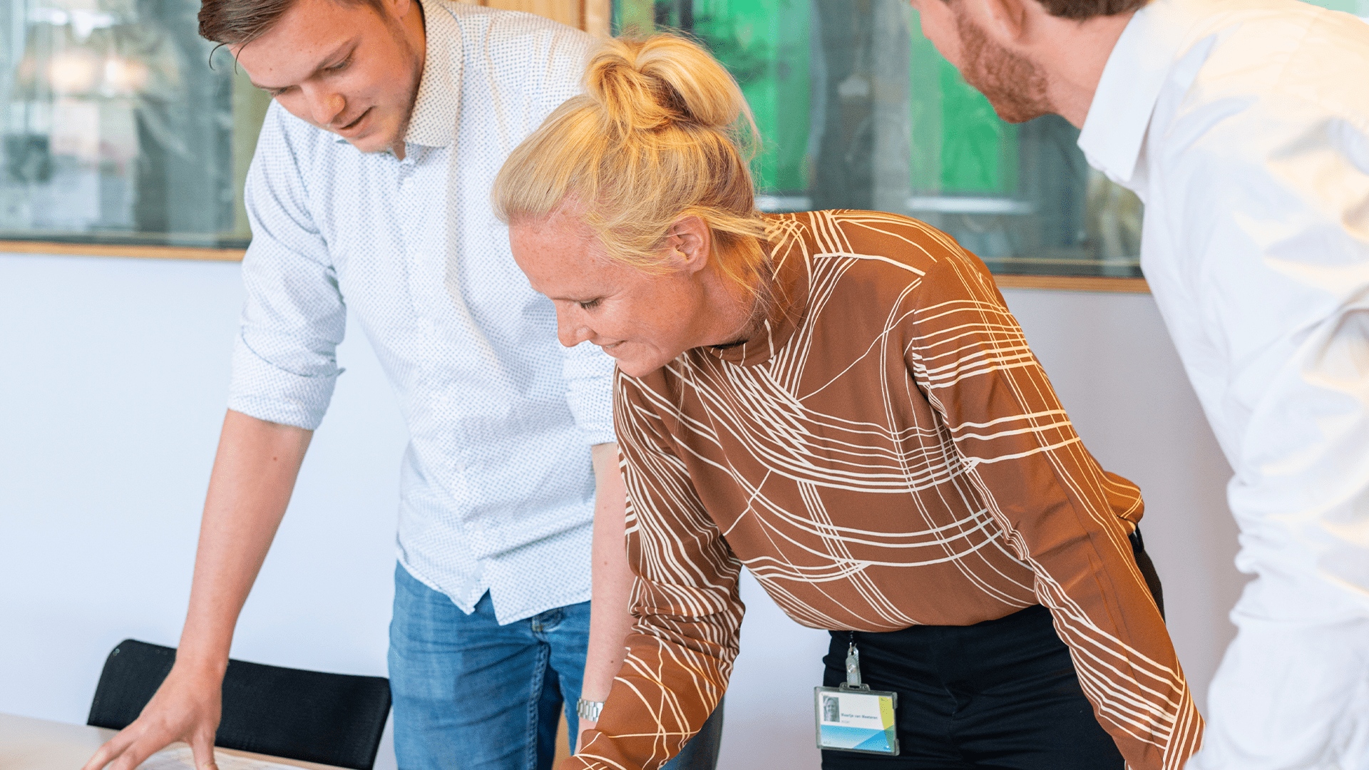 Collega's van Haskoning staan samen rond een tafel en bespreken een project