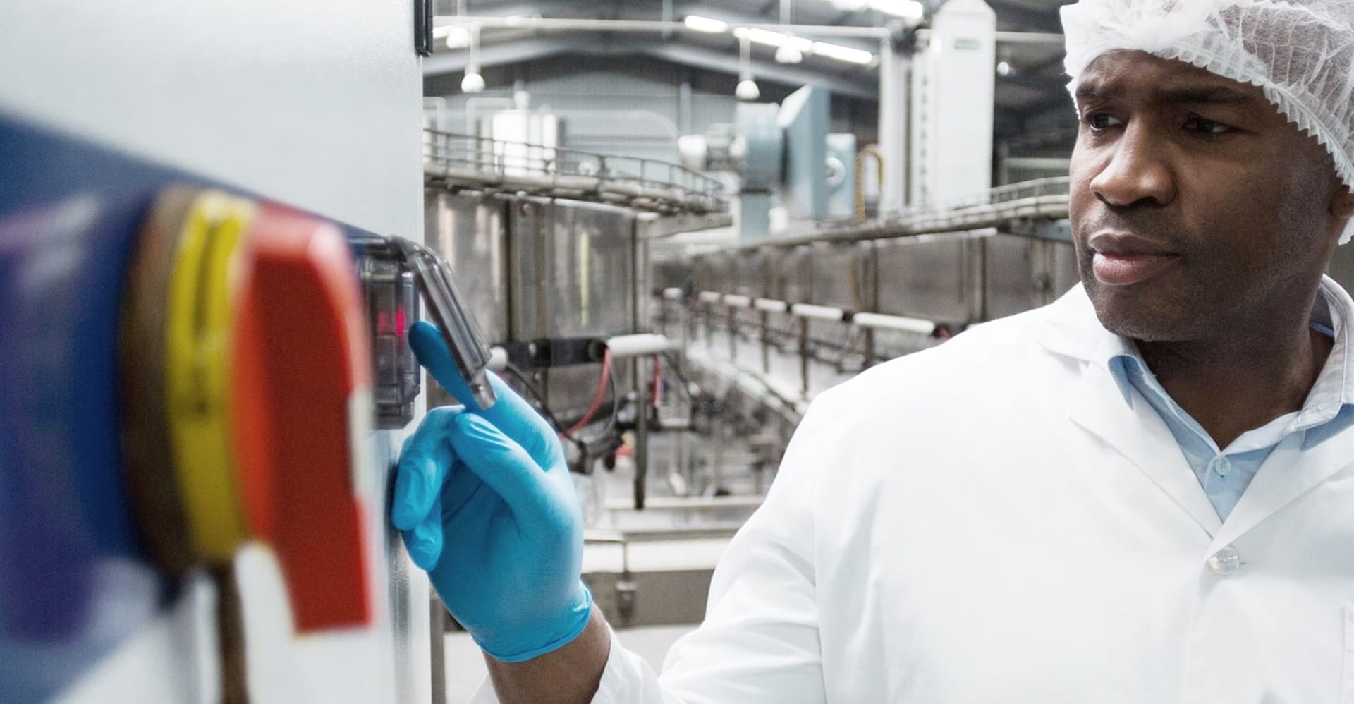 Industrieel technicus die machines bedient in een moderne fabrieksomgeving.