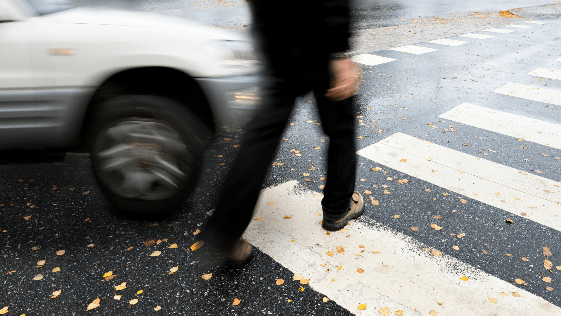Man die op het punt staat geraakt te worden door een auto, de stoep oversteekt.