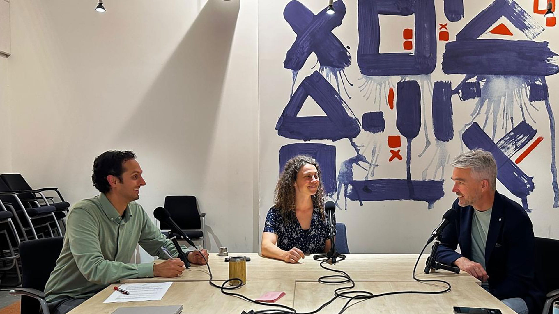 Mensen aan een tafel om een podcast te maken over Achmea Real Estate