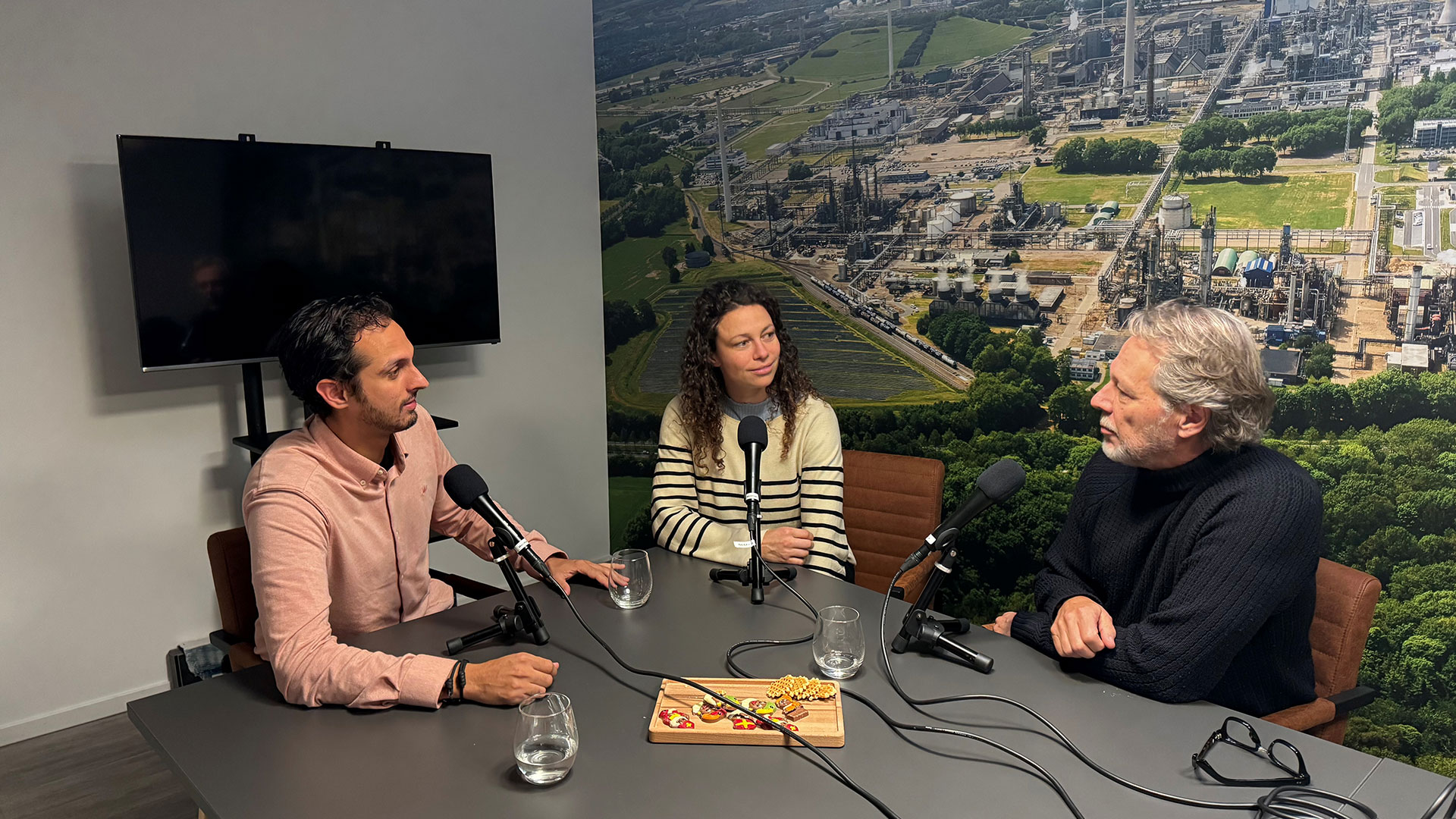 Mensen aan een tafel om een podcast bij Chemelot op te nemen.