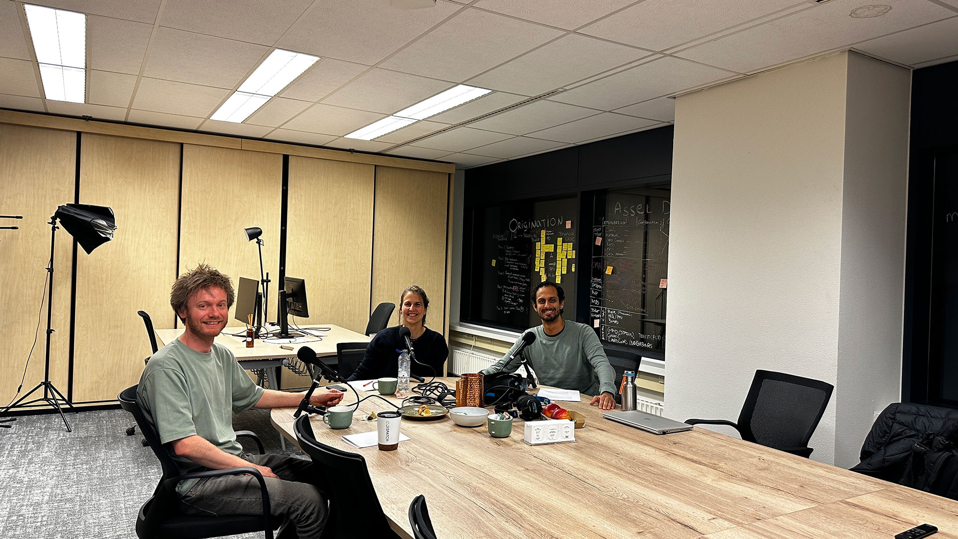 Mensen aan een tafel om een podcast aflevering bij Dispatch op te nemen.