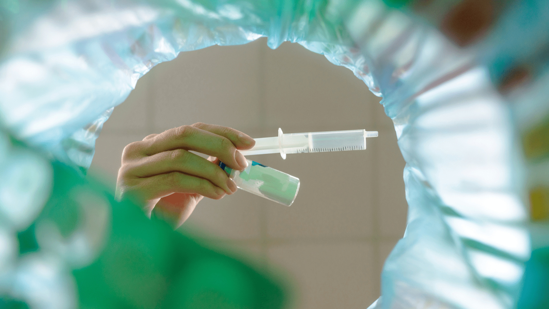 Gebruikte medische spuiten worden in een afvalbak gegooid