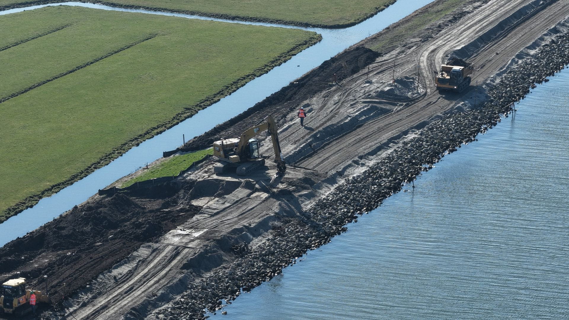 Graafmachines aan het werk met de ondergrond van de dijk bij Marken