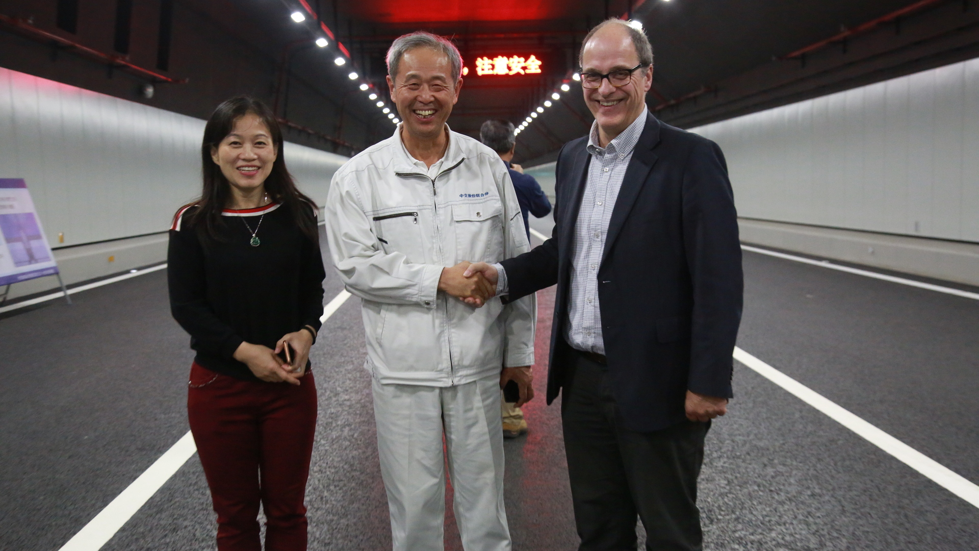 Ying Li (links) en Hans de Wit (rechts) met Mr. Lin Mign (midden), General manager of HZMB Island and Tunnel Project, bij de Macau Bridge (HZMB) Fixed Link in Hong Kong