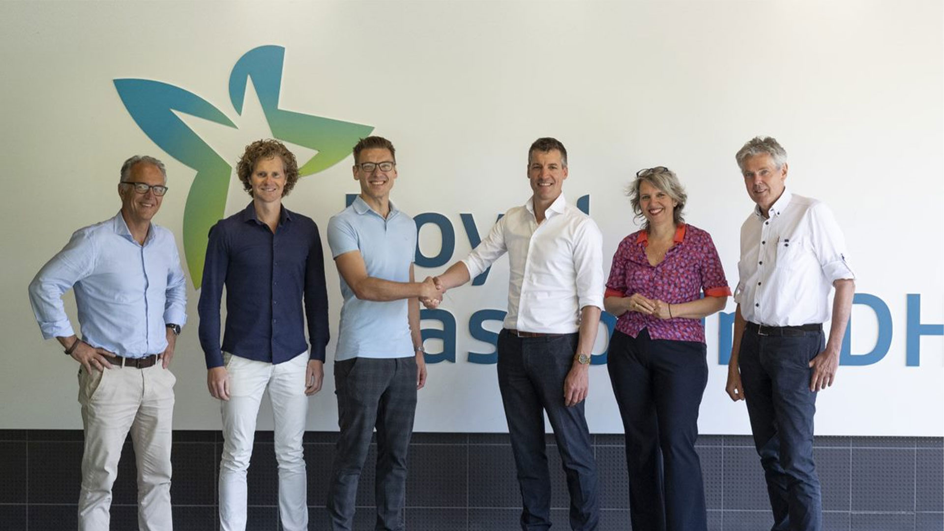 RHDHV colleagues sitting in front of the Amersfoort office shaking hands