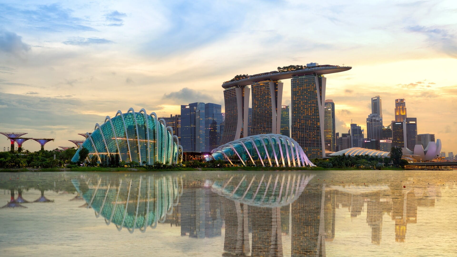 Zonsondergang bij Marina Bay Sands en Gardens by the Bay in Singapore, een weerspiegeling van innovatie en wereldwijde reikwijdte.