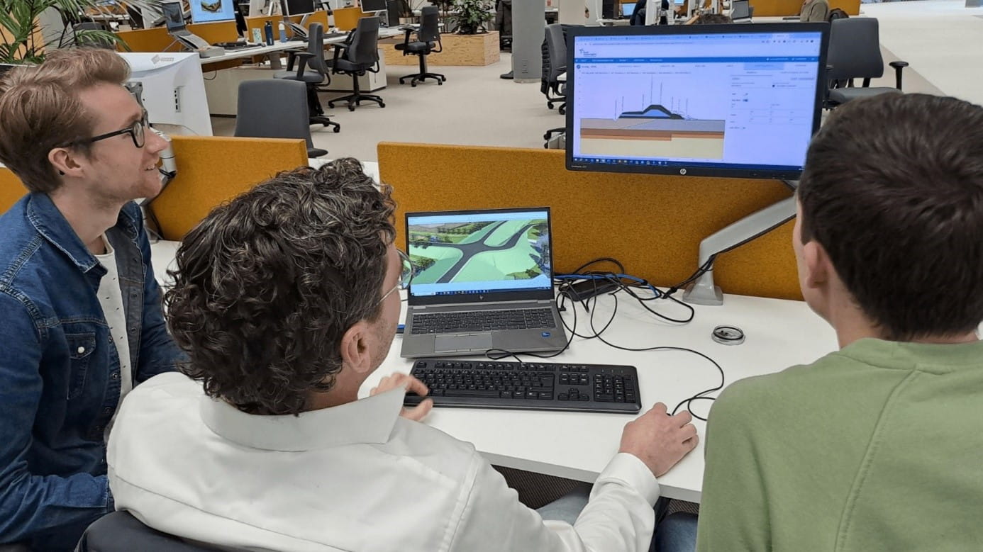 Drie mensen kijken naar een dijkontwerp in de Dike Resilience Suite software.