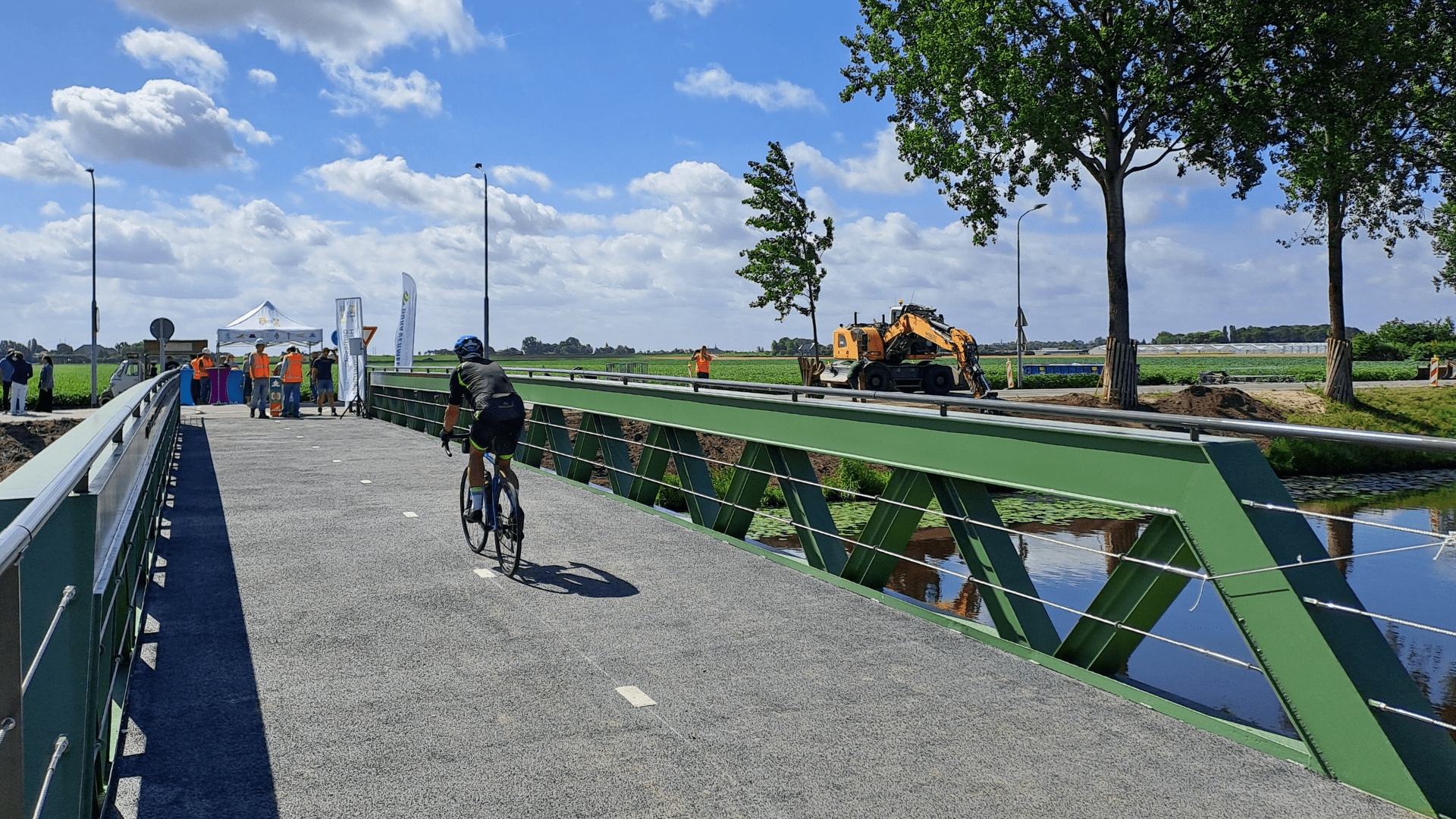 Foto van een nieuwe fietsbrug in Abbenes met daarop een wielrenner