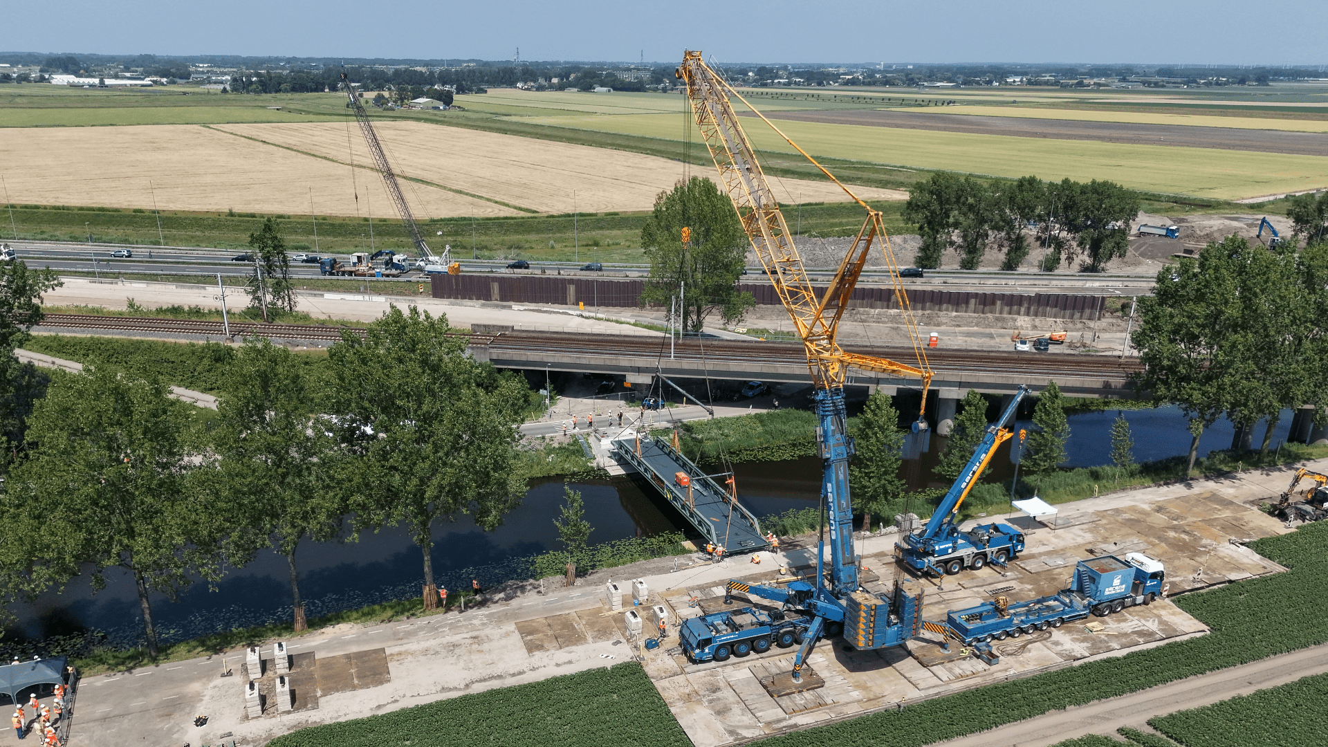 Luchtfoto van het inhijsen van een fietsbrug bij Abbenes
