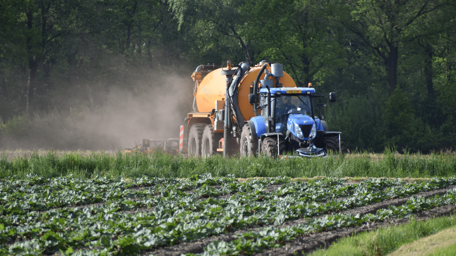 Afbeelding van traktor en machine in een veld met landbouw