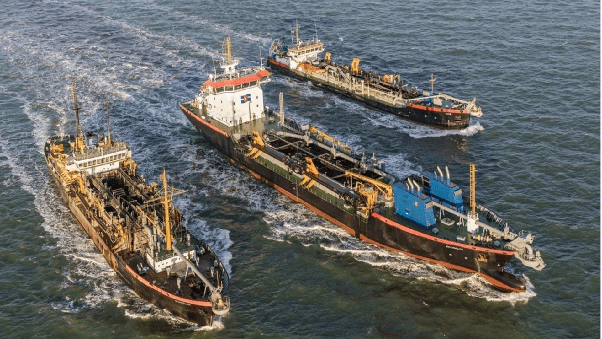 Luchtfoto van meerdere baggerschepen die samen werken op zee