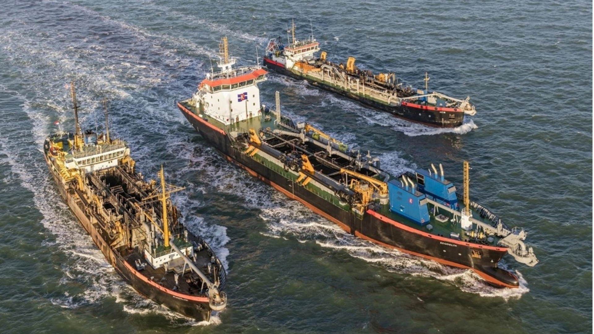 Luchtfoto van meerdere baggerschepen die samen werken op zee