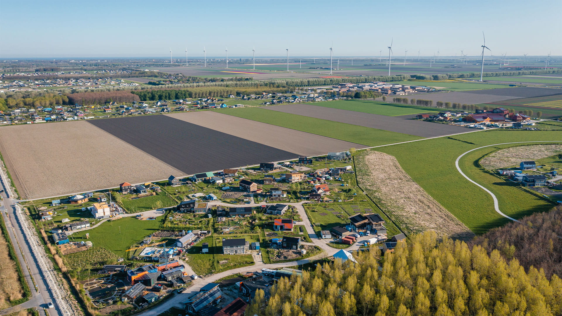 Landelijk gebied met huizen, bomen en akers vanuit de lucht bekeken